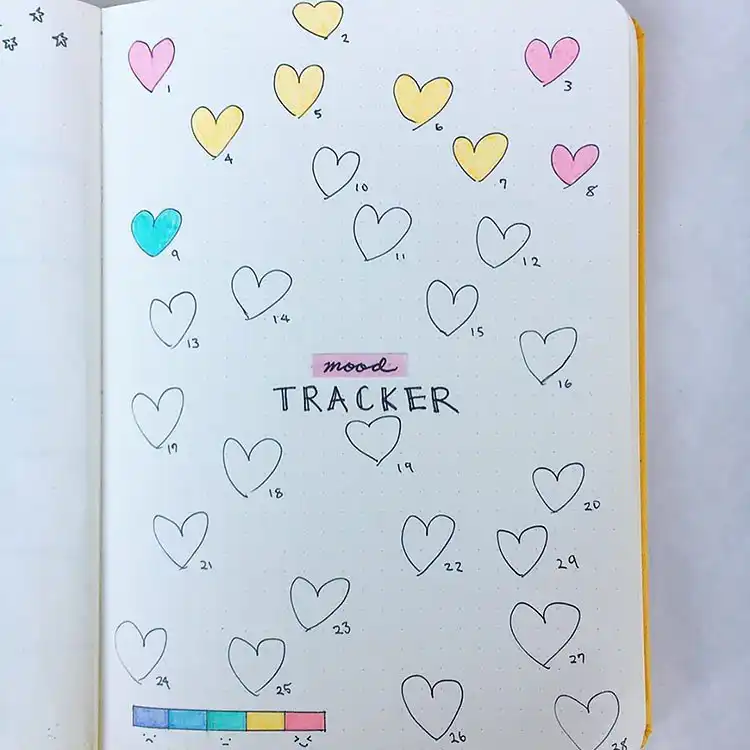 Colorful weekly planner in a bullet journal with hand-drawn flowers hanging from the top and bubble font 'February'.