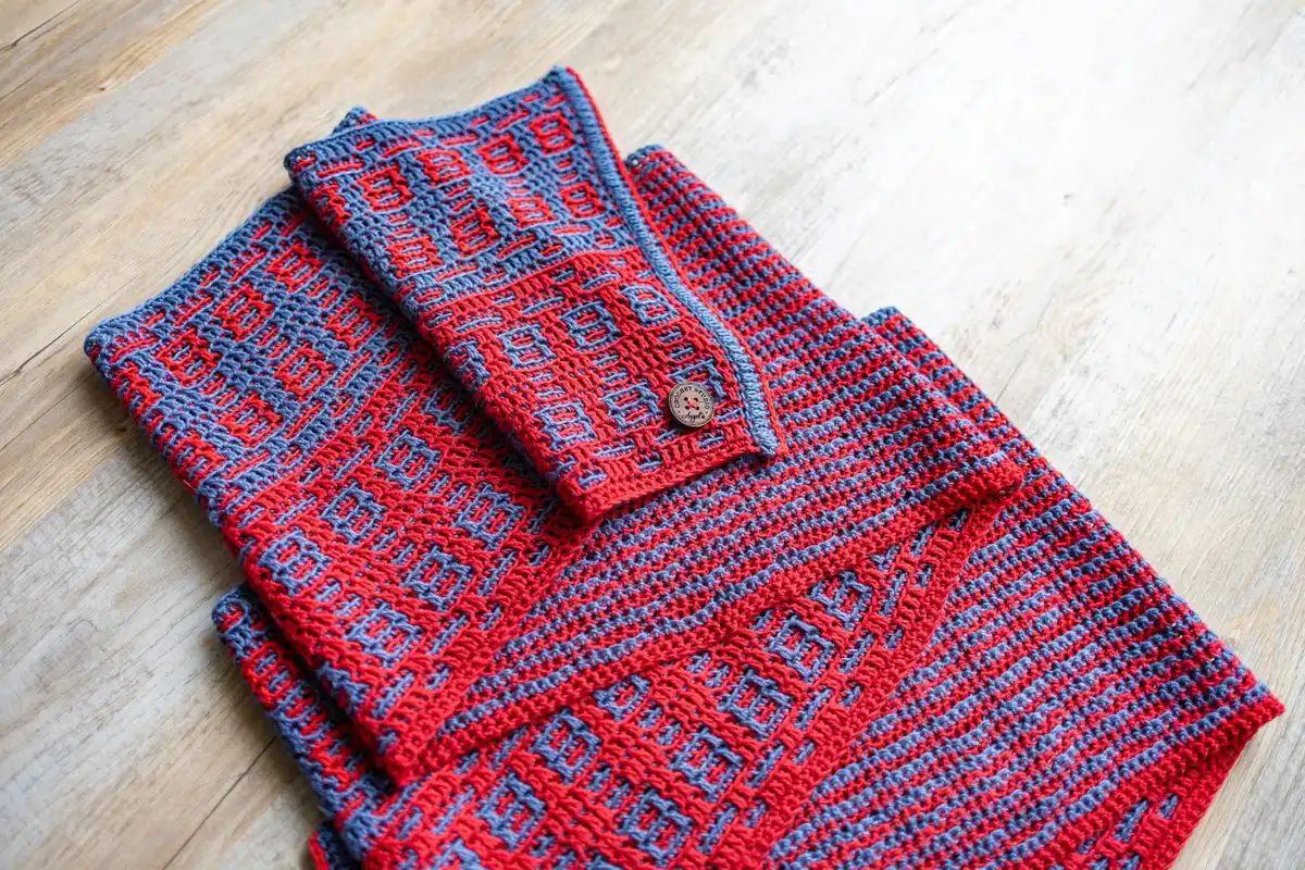 Neatly folded crochet mosaic scarf in blue and red, showing the intricate design of the Fire and Ice Scarf Free Crochet Pattern.