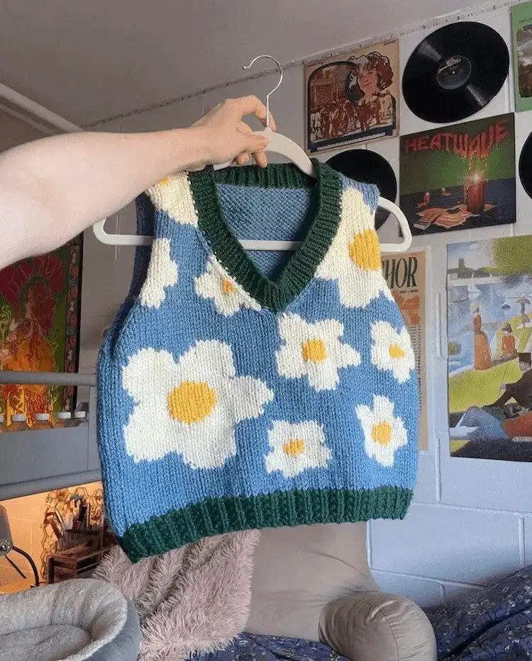 A cheerful Blossom Vest with a daisy knit motif, perfect for spring and summer wear.