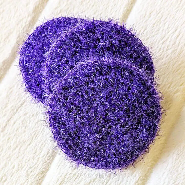 Three colorful, neatly crocheted scrubby pieces in various stages, demonstrating the initial pattern steps for the Free Crochet Dish Scrubby Pattern - Easy Gift Idea.