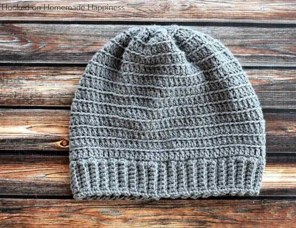 Two finished crocheted beanies with pom-poms, representing the 1.5 Hour Beanie from Free Crochet Hat Patterns for Babies and Kids.