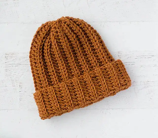 Three colorful beanie hats with pom-poms, illustrating the Beginner Winter Hat from Free Crochet Hat Patterns for Babies and Kids.