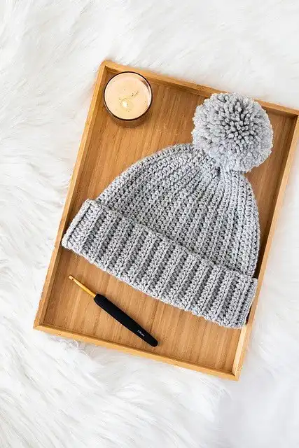A brown crocheted ribbed beanie hat resting on a wooden surface, representing the Ribbed Wonder Easy Hat from Free Crochet Hat Patterns for Babies and Kids.
