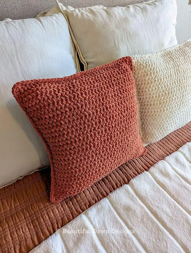 Close-up of the Bernat Blanket yarn and crochet hook alongside poly-fil, essential materials for the Free Crochet Pillow Pattern Using Super Bulky Bernat Blanket Yarn.
