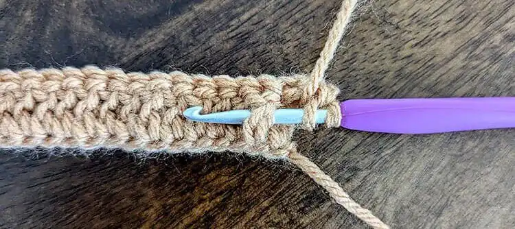 Close-up of a front post double crochet (FPdc) stitch being created as part of the Free Crochet Waffle Kindle Case Pattern.