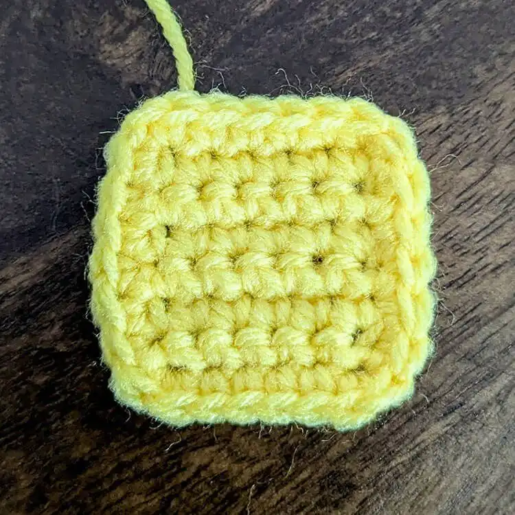 The crocheted yellow butter pat piece for the Free Crochet Waffle Kindle Case Pattern, ready for assembly.