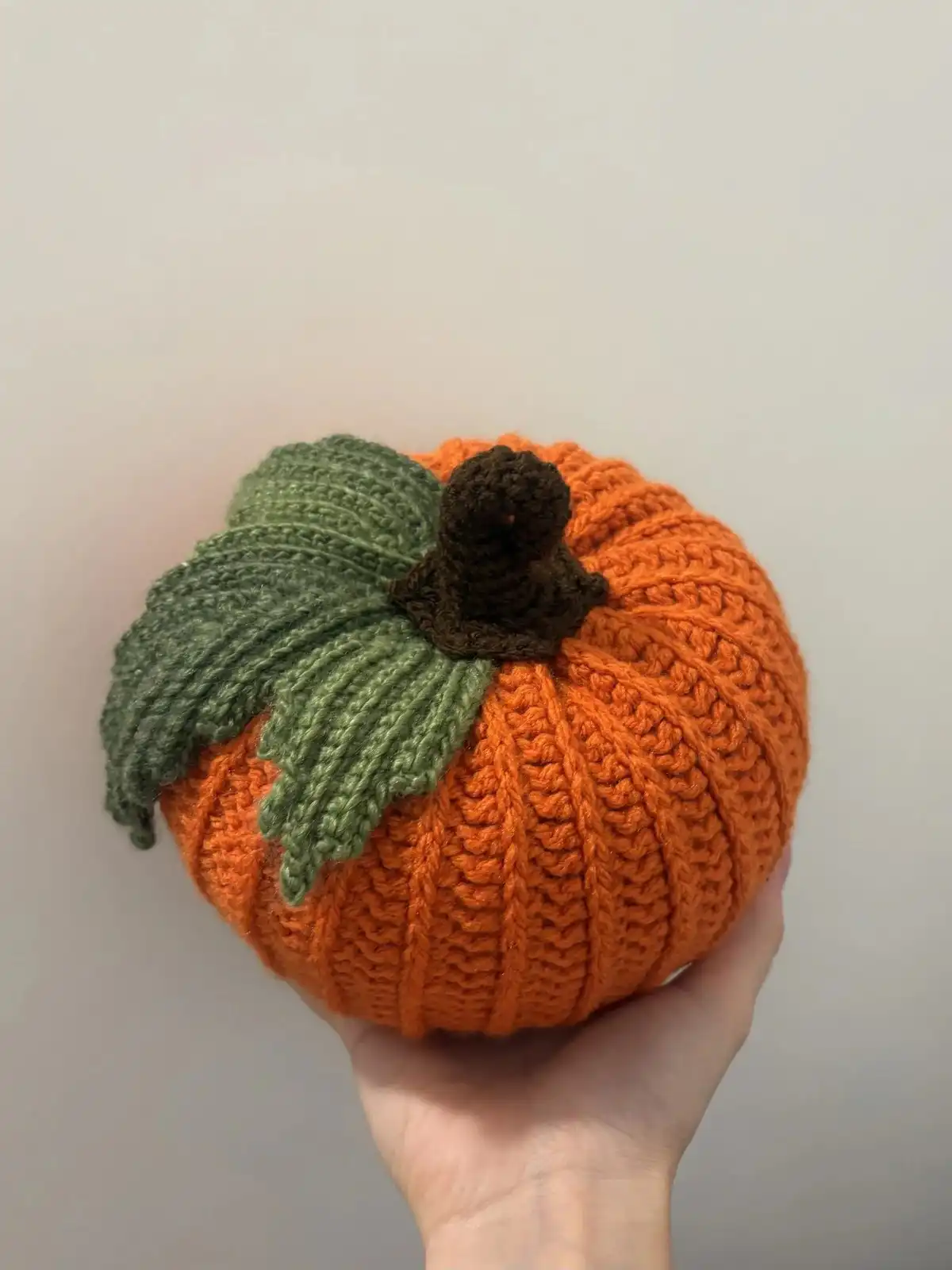 A charming arrangement of five crocheted pumpkins in various colors (yellow, orange, teal, green) with cinnamon stick stems, creating a 'Pumpkin Patch' by Brenda K. B. Anderson.