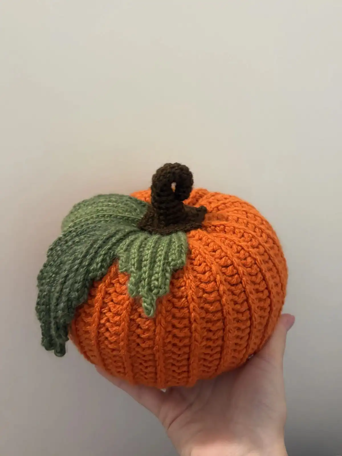 Three neutral-toned crocheted pumpkins (white, brown, beige) with matching green leaf coasters, showcasing the Briana K Designs set.