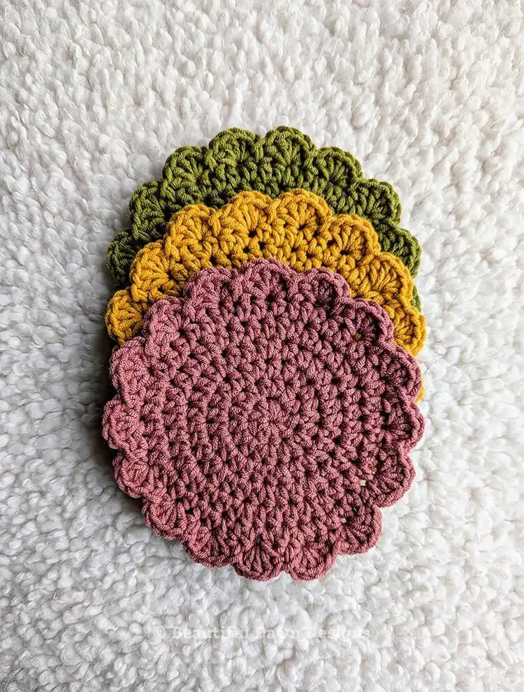 Close-up of yarn, crochet hook, and stitch marker, essential materials for the Free Quick and Easy Crochet Coaster Pattern - Great Handmade Gift Idea