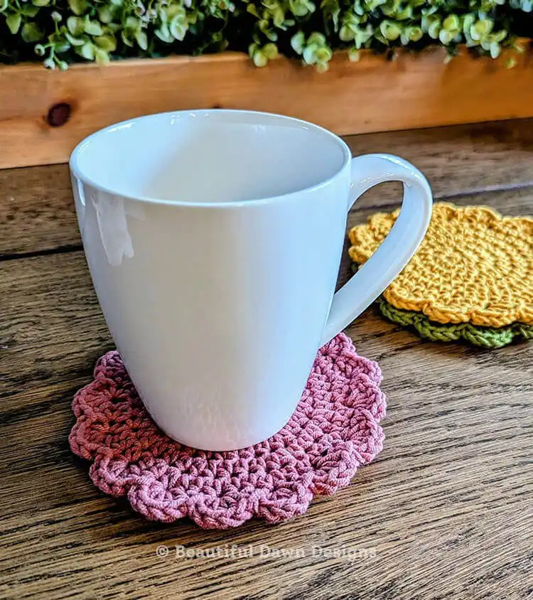 A mug resting on a freshly crocheted coaster, demonstrating its use and flat lay for the Free Quick and Easy Crochet Coaster Pattern - Great Handmade Gift Idea