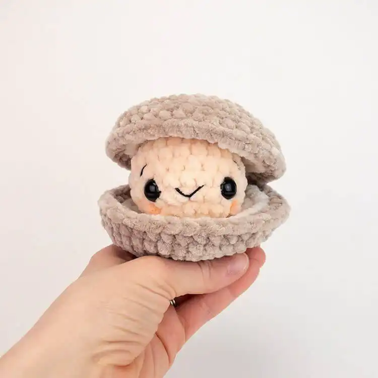 A cuddly white No Sew Polar Bear amigurumi with a red scarf.