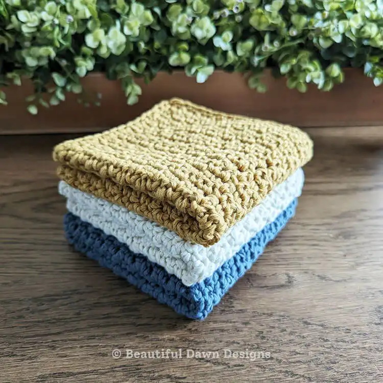 Featured image of two modern textured crochet dishcloths in grey and cream, showcasing the griddle stitch.
