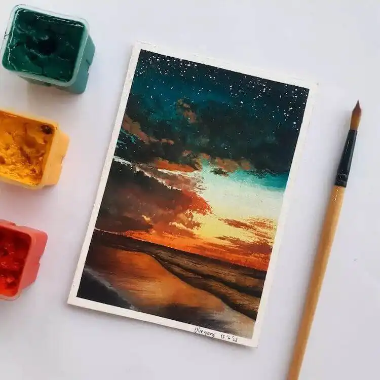 Calming blue lake watercolor painting with mountains and trees at sunset, perfect for Get Creative with These Gorgeous Sunset Painting Ideas