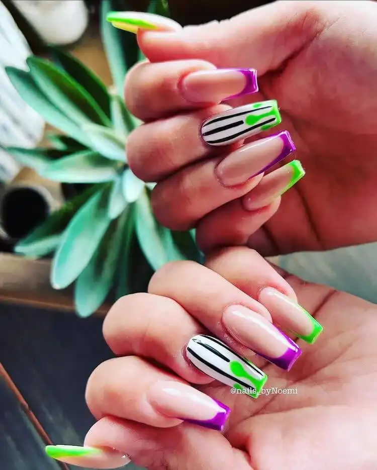 Trendy Glow in the Dark Beetlejuice Nails with a modern French tip design featuring black and white stripes.