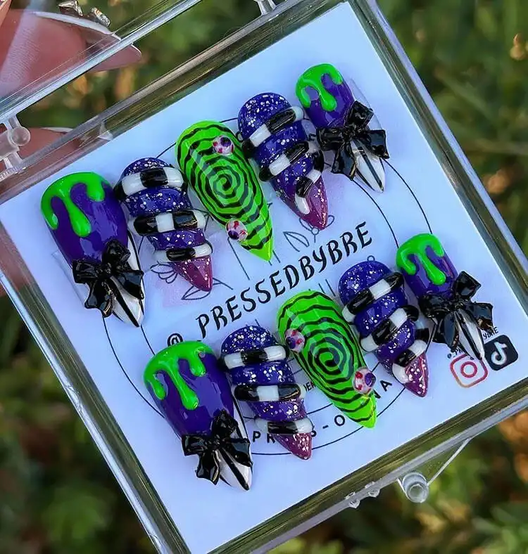Creative Glow in the Dark Beetlejuice press-on nails featuring fun cartoonish designs and vibrant colors.