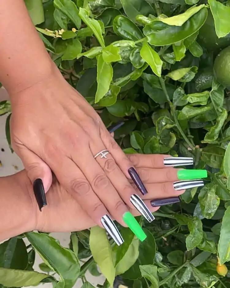 Classic Glow in the Dark Beetlejuice Nails featuring iconic black and white vertical stripes on various nail shapes.