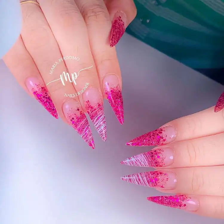 Pink spun sugar stiletto nails with a unique glittery and textured finish, perfect for a fun and eye-catching look.