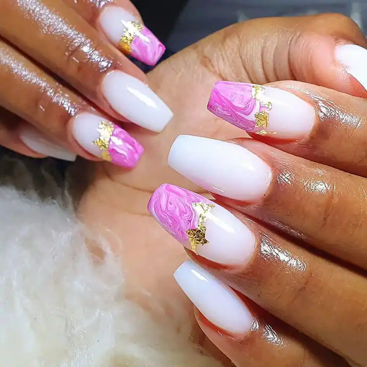 Pink marble nail tips adorned with luxurious gold flakes, creating a sophisticated and eye-catching design.