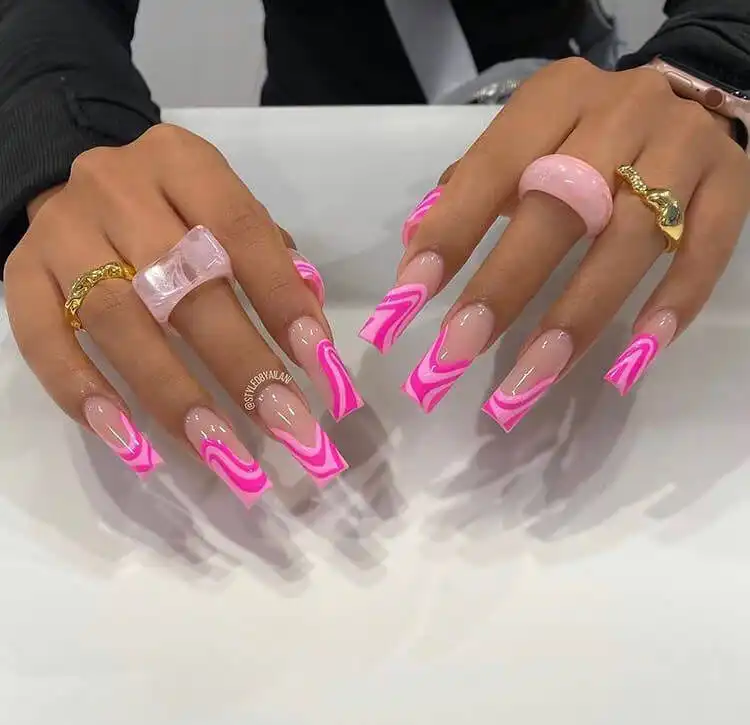 Long coffin nails featuring a beautiful and artistic pink swirl design, adding a dynamic touch to the manicure.