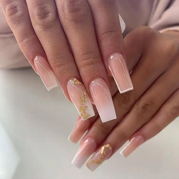 Elegant ombre nails with an almost clear design, accented with delicate gold flakes, perfect for any special event.