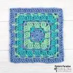 A detailed section of a Battenberg Blanket, displaying a checkerboard pattern of plain and colorful granny squares joined together with a delicate picot edge.
