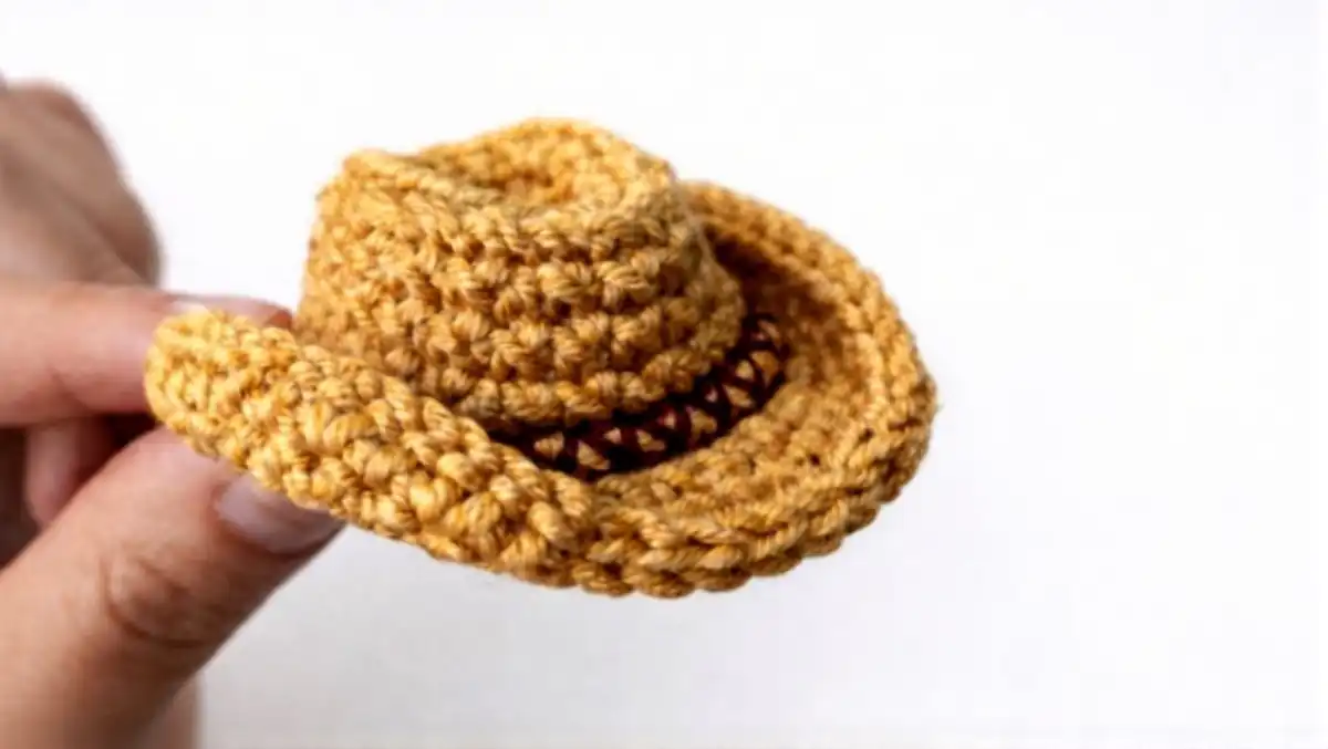 A perfectly crocheted mini cowboy hat showcasing its beginner-friendly step-by-step pattern details and classic Western shape.