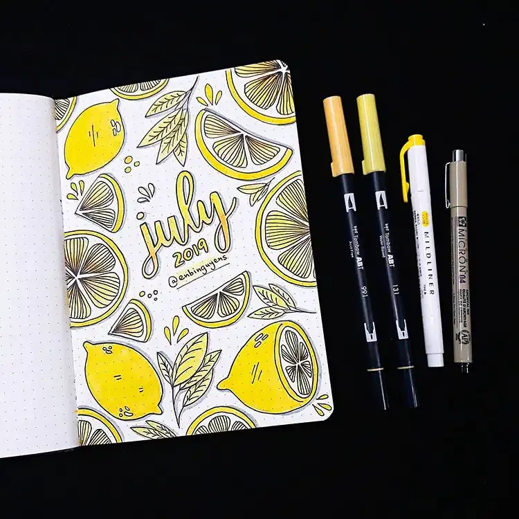 July Bullet Journal Cover Page Ideas 3 July bullet journal cover with bright yellow lemons and green leaves, featuring gradient text.