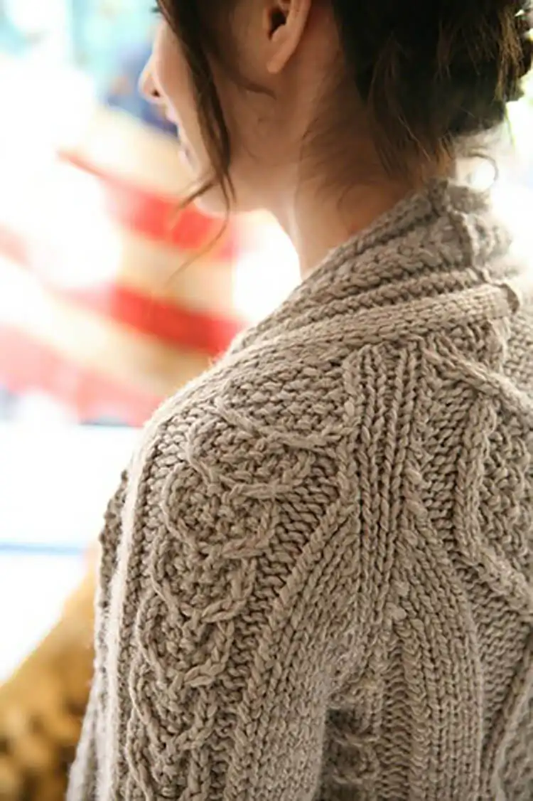 Textured Aidez Cardigan featuring intricate cable patterns, perfect for intermediate knitters.
