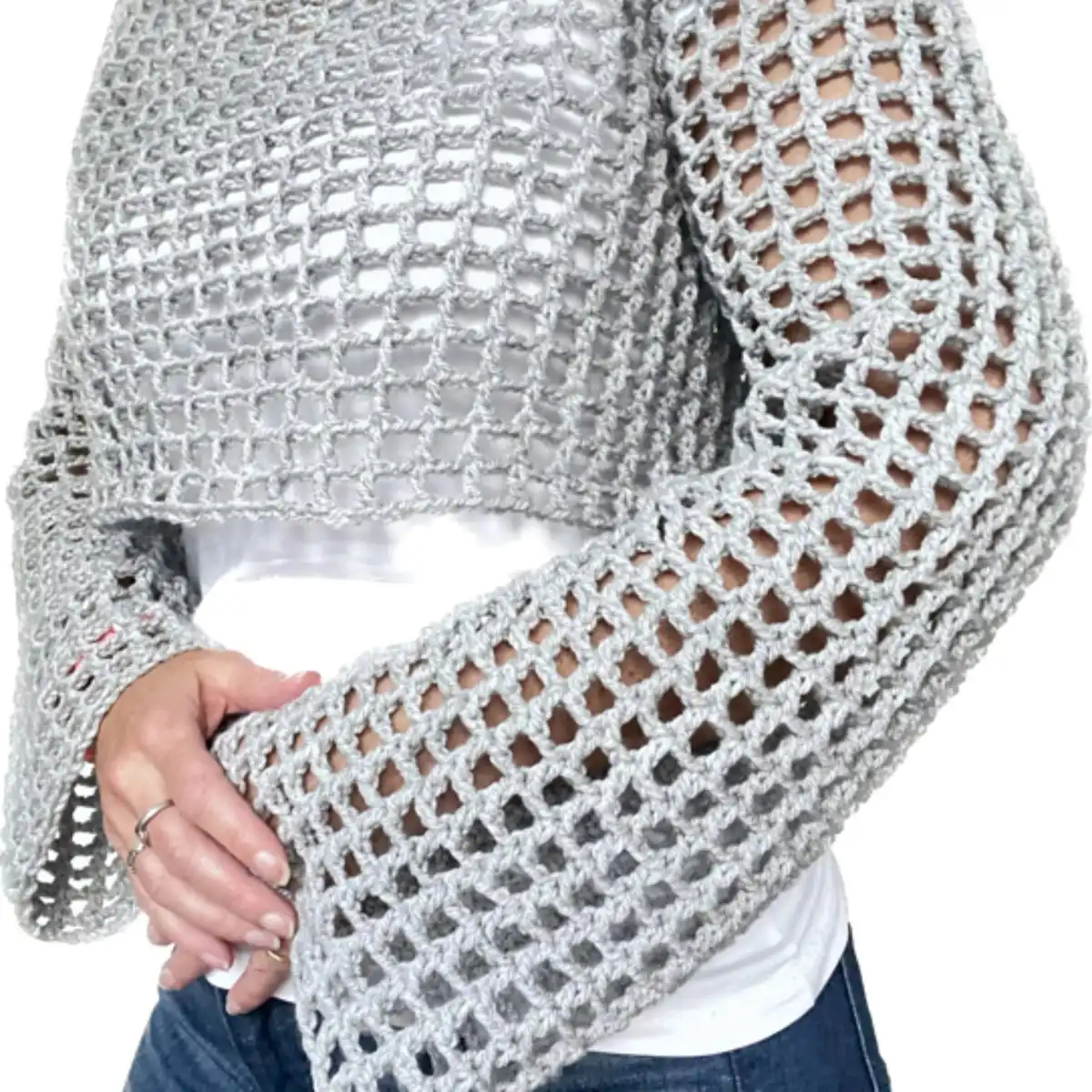 Person wearing a crochet crop top with a solid upper section and a lower band featuring colorful floral motifs.