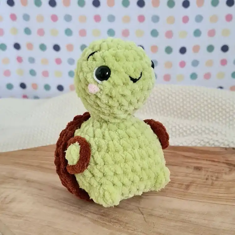 An adorable crochet 'Trunk the Turtle' amigurumi with a distinctive patterned, removable shell.