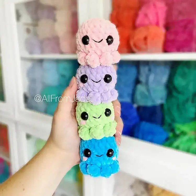 A collection of colorful squishy baby crochet octopi, featuring their signature curly tentacles and friendly faces.