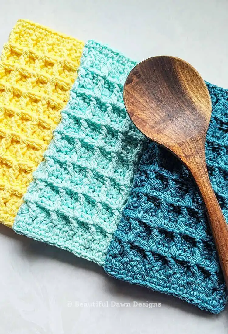 A textured white crochet waffle stitch dishcloth, highlighting the deep pockets and absorbent quality of the stitch.