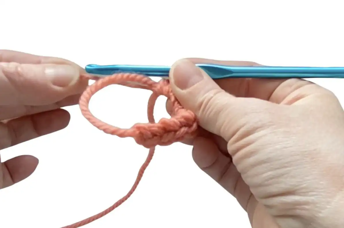 Step 8: Inserting hook into loop and making the first single crochet stitch.