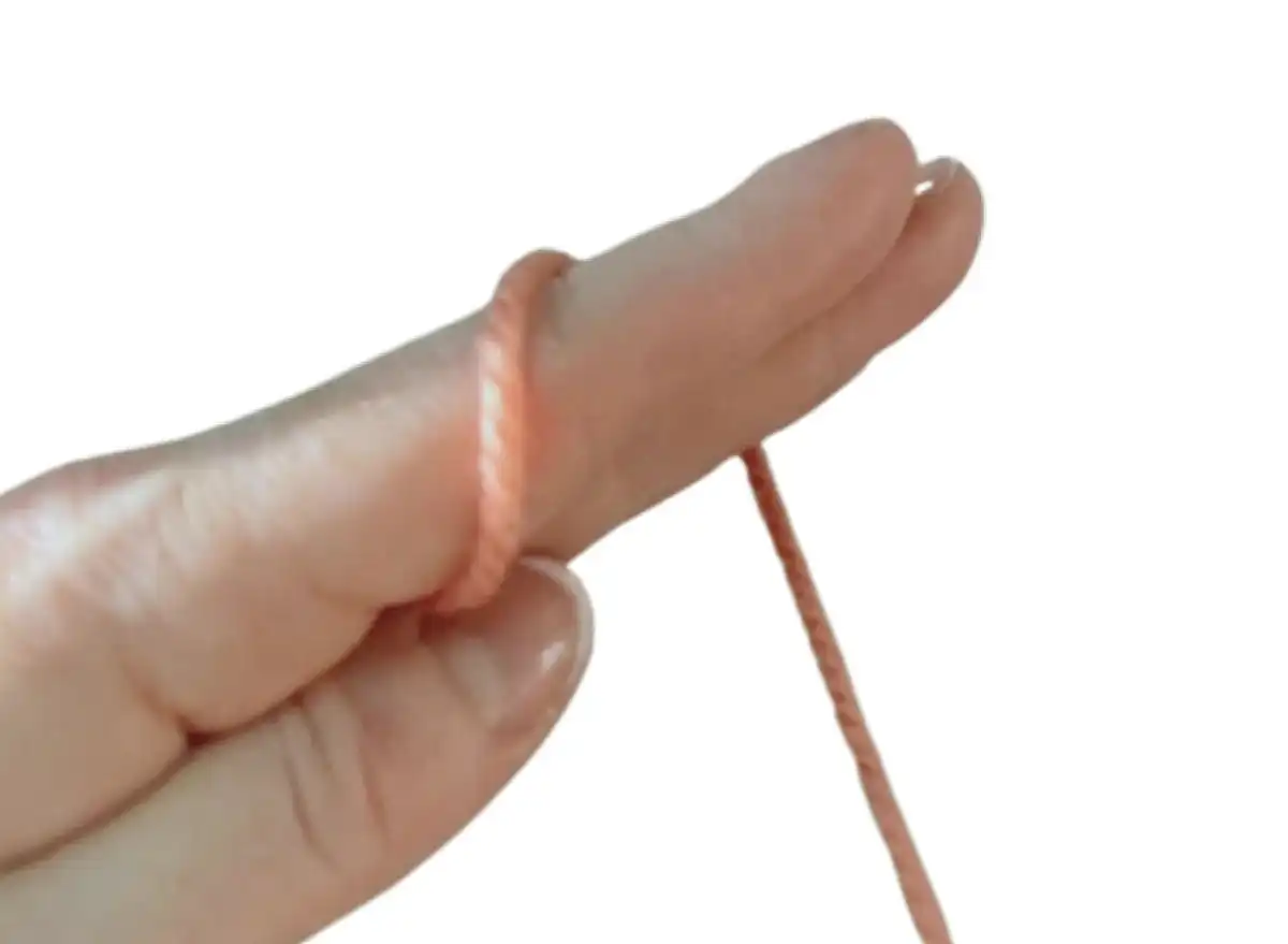 Step 1: Placing yarn across the palm for the magic ring.