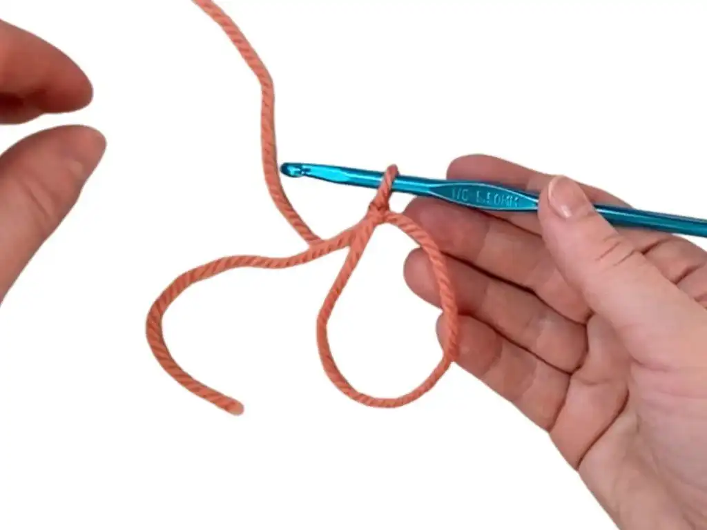 Step 5: Inserting hook under working yarn and making a chain for magic ring.