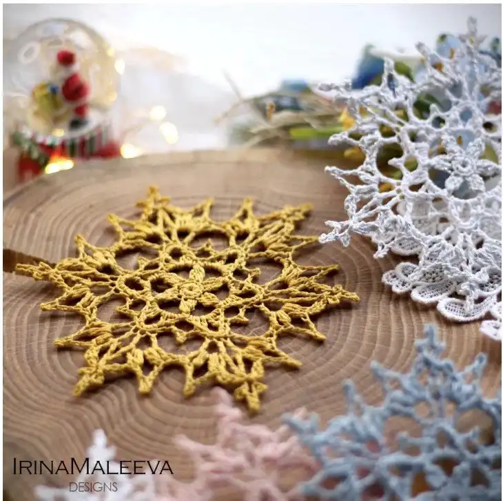 An elegant 'Frostarra Snowflake' crochet pattern in blue and white, highlighting its intricate design perfect for holiday appliques.