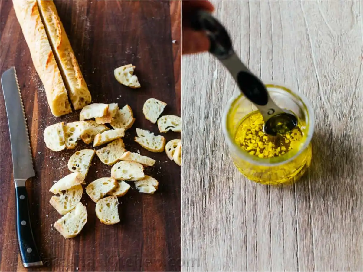 Baguette slices being tossed with garlic-infused olive oil and grated Parmesan cheese on a baking sheet to make croutons.