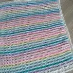 Vibrant Bloque Stitch Blanket with solid, thick fabric, ideal for warmth and durability in a baby's nursery.