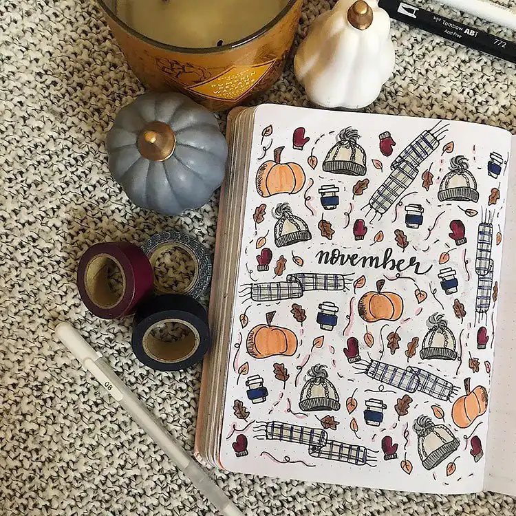 November cover page filled with fall elements like pumpkins, hats, scarves, leaves, and hot drinks