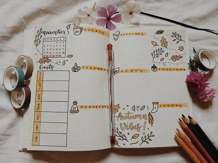 Fall weekly planner spread with 'Autumn Vibes' quote, using warm fall colors for a cozy layout