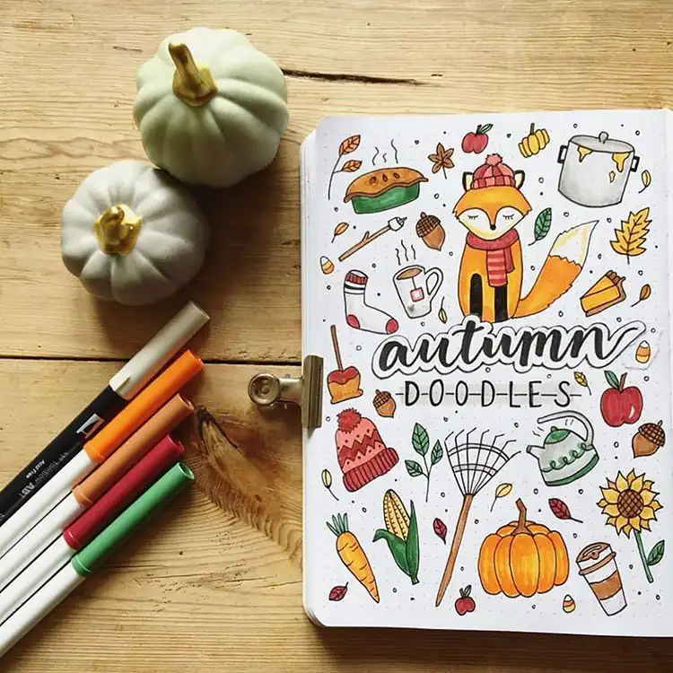 Classic October bullet journal cover page with an array of sketched pumpkins and fallen autumn leaves.