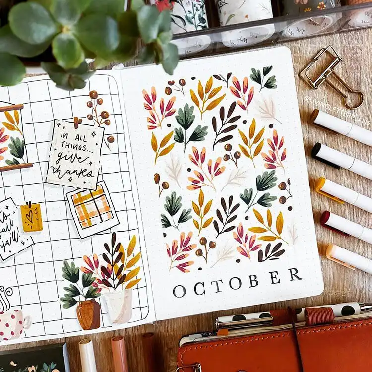 October bullet journal cover page filled with illustrations of hot drinks, autumn leaves, and acorns.