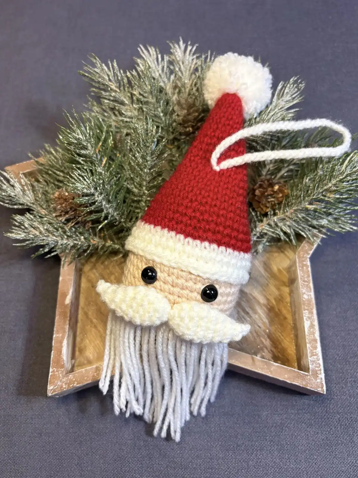 Personalized Christmas Baubles – Custom & Free Crochet Ornament Patterns 8 A festive Santa Frame Ornament, a crocheted red and white Santa head designed to hold a small circular photograph, making a personal Christmas bauble.