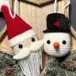 Personalized Christmas Baubles – Custom & Free Crochet Ornament Patterns 10 A charming crocheted snowman head with a carrot nose and rosy cheeks, ready to be hung as a delightful Christmas decoration or garland piece.