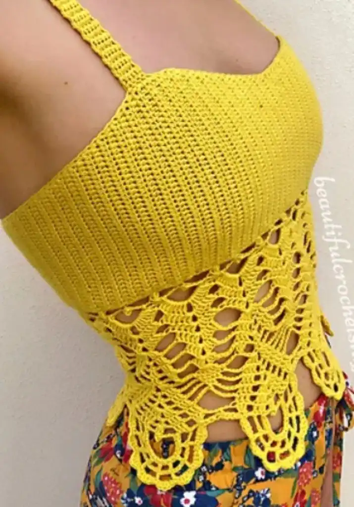 Yellow lacy crochet crop top with intricate details, paired with floral pants for a boho summer outfit.