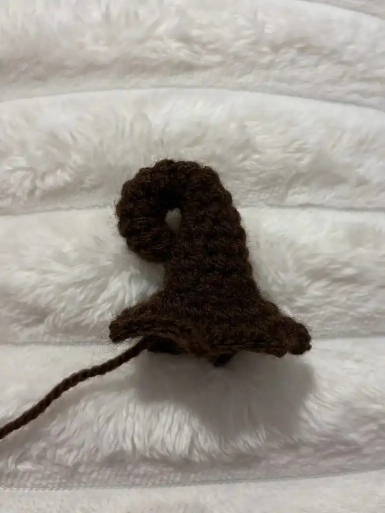 A partially crocheted dark green piece, showing the initial rows of the leaf for the Pumpkin Free Crochet Pattern.