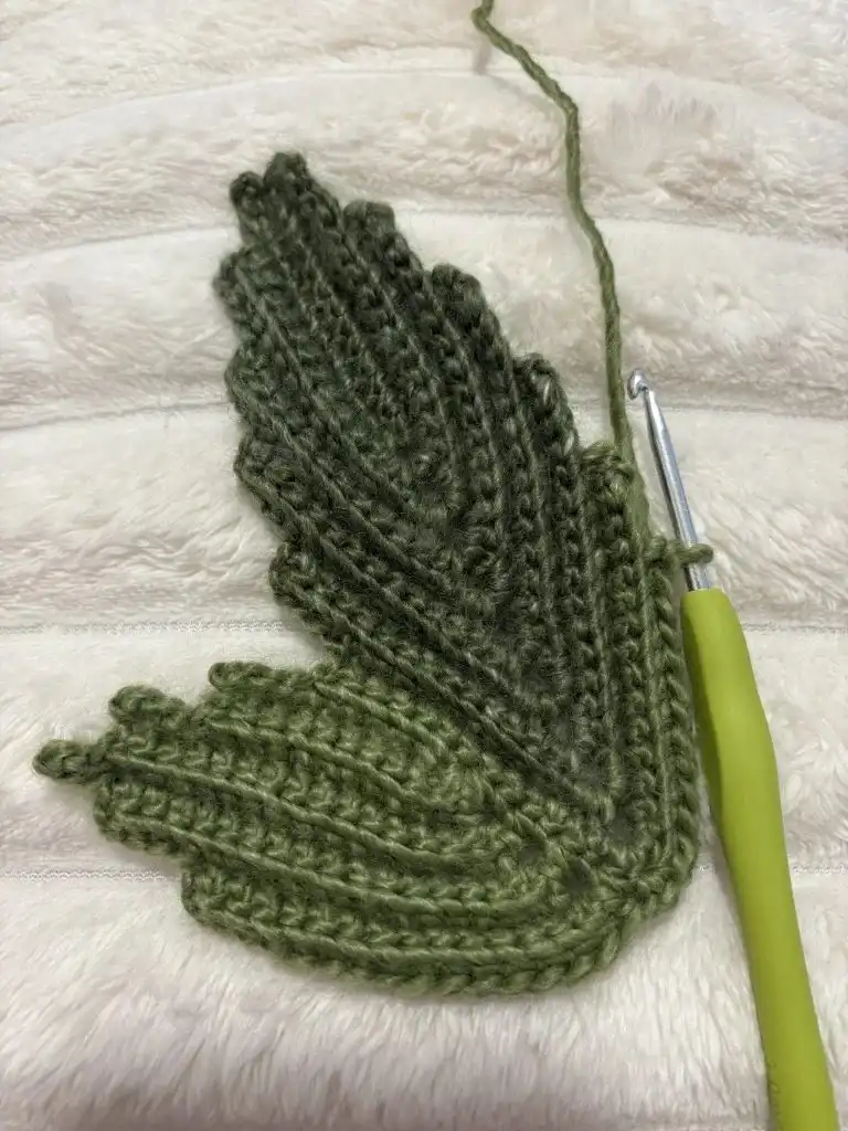 The orange pumpkin panel folded in half and being single crocheted together, forming the pumpkin's cylindrical body.