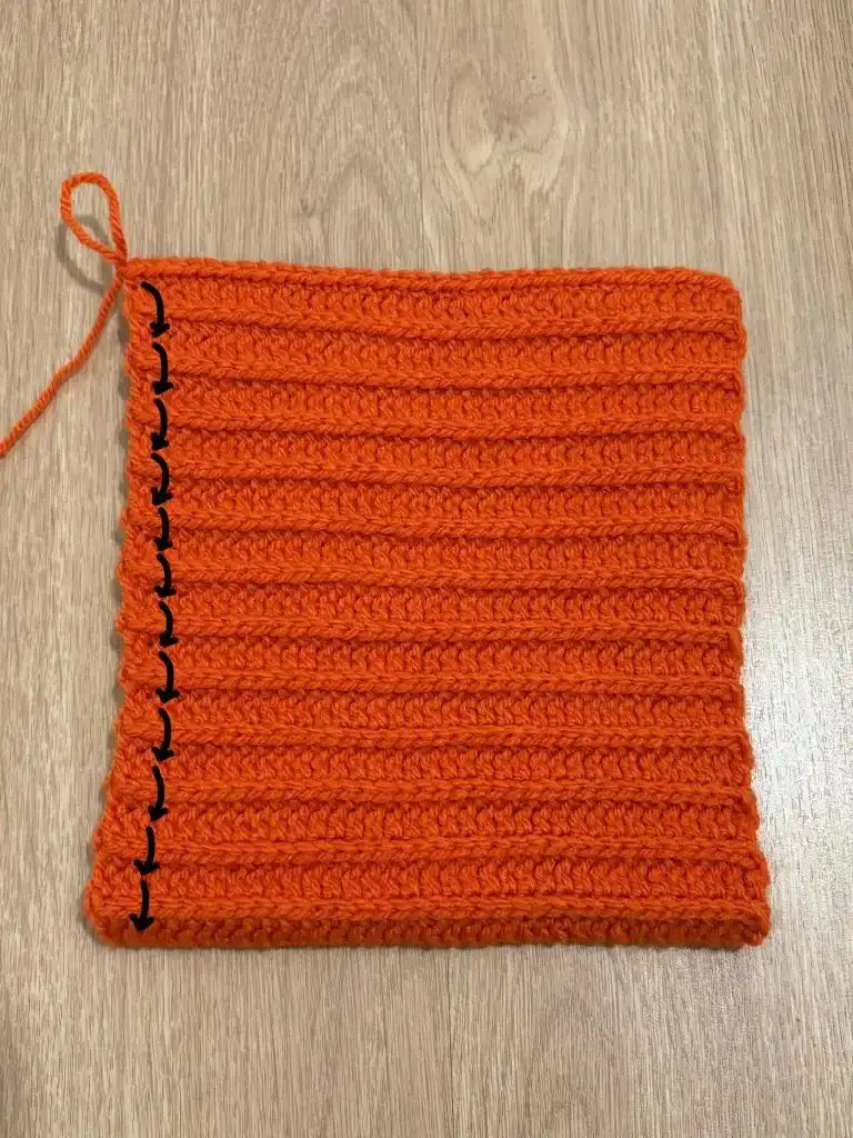 The partially assembled pumpkin resembling a beanie hat, with stuffing being added to shape it.