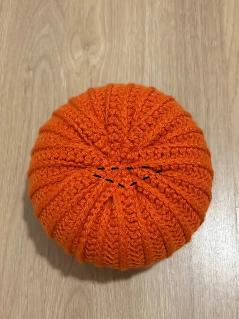 Securing the leaf with a tie underneath, illustrating the final steps for a neat finish before hiding the yarn.