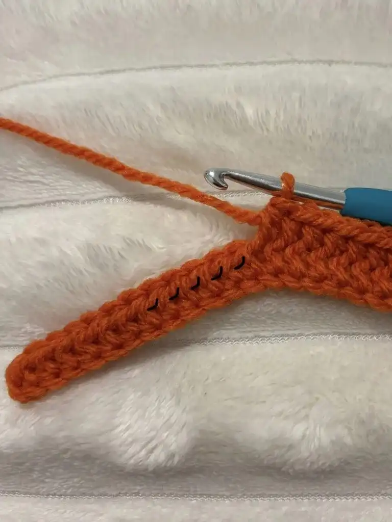 A close-up of an orange crochet panel in progress, highlighting the textured ridges created by the TLO stitches for the Pumpkin Free Crochet Pattern.